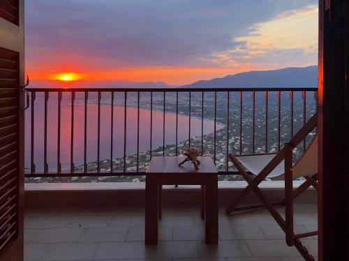 a room with a balcony with a table and a sunset at Gaia (Γαία) guest house in Kalamata