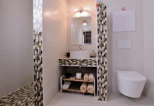 a bathroom with a sink and a toilet and a mirror at Meridián-apartmán, Starý Smokovec, PRIMO, Vysoké Tatry in Vysoke Tatry - Stary Smokovec