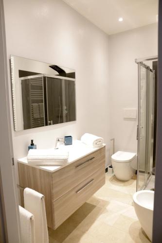 a bathroom with a sink and a toilet and a mirror at Ad Astra Rooms in Ravenna