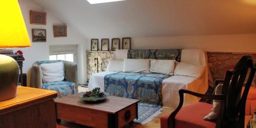 sala de estar con cama y silla en Les Glycines Bed & Breakfast, en Eymet