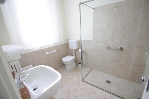 a bathroom with a toilet and a glass shower at Ad Astra Rooms in Ravenna