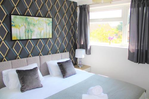 a bedroom with a white bed and a window at Homely and Budget Friendly 3 bed house Sleeps 6 Free Parking! in Milton Keynes