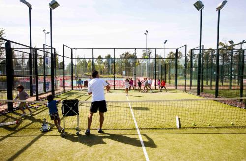 a group of people playing tennis on a tennis court at Vincci Valdecañas Golf in El Gordo