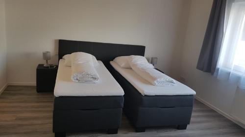 a bed and two ottomans in a room at Air Rooms Hotel in Kelsterbach