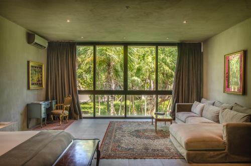 a living room with a couch and a large window at Casa Malca in Tulum