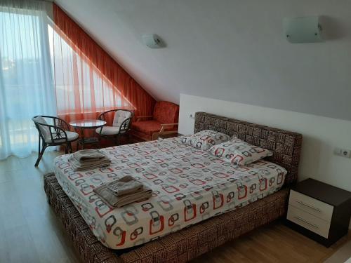 a bedroom with a bed and a table and chairs at Alexander Lozenets Beach Complex Apartment in Lozenets
