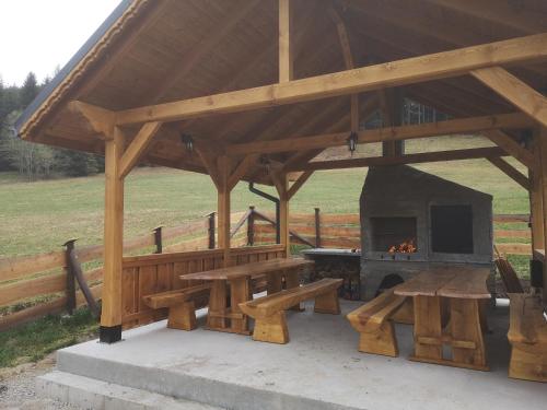 een houten paviljoen met een picknicktafel en een open haard bij Domki na Zagroniu in Koninki