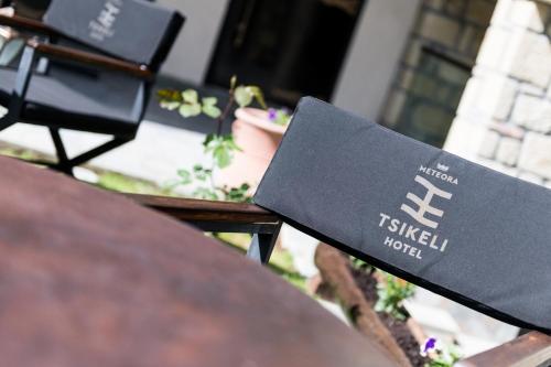 a bench with a sign on it sitting at a table at Tsikeli Boutique Hotel Meteora - Adults Friendly in Kalabaka