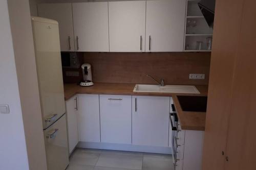 a kitchen with white cabinets and a sink at helle Souterrainwohnung nähe Flughafen, Landshut und München 1 bis 5 Personen in Bruckberg