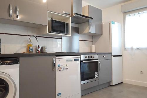 une cuisine avec un réfrigérateur et un lave-vaisselle dans l'établissement T3 Spacieux, Renové en 2020 -Pkg-métro, à Toulouse