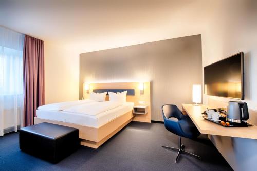 ein Hotelzimmer mit einem Bett und einem Schreibtisch in der Unterkunft Hotel Sachsen-Anhalt in Barleben