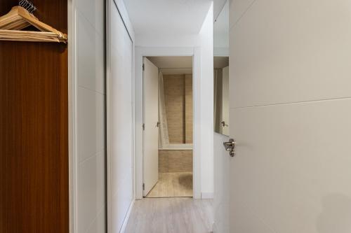 un pasillo con una puerta que conduce a un baño en BNBHolder Terrace, Pool & Gym LAS TABLAS en Madrid
