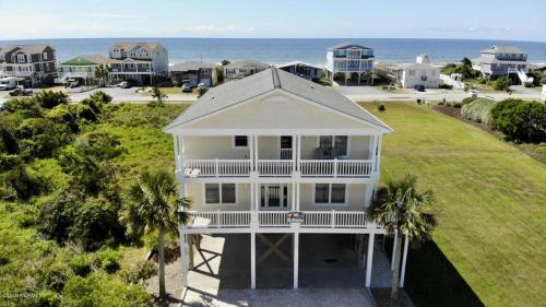 an aerial view of a white house with the ocean in the background at Salt, Sand and Sudds home in Holden Beach