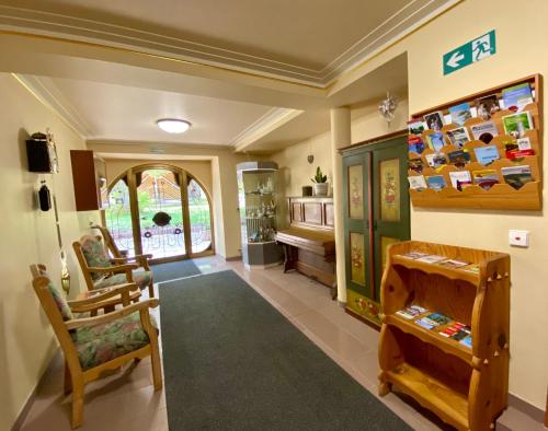 a living room with chairs and a room with a piano at Gasthaus Staude in Triberg