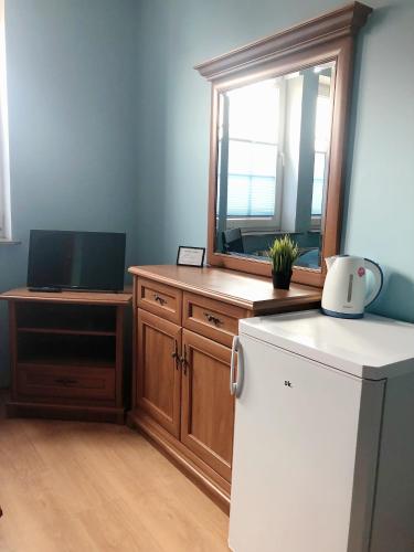 a kitchen with a white refrigerator and a mirror at Dom Aptekarza in Ustka