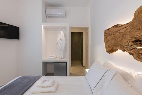 a bedroom with a bed with a wooden head board at Sunset Paraportiani Rooms in Mýkonos City
