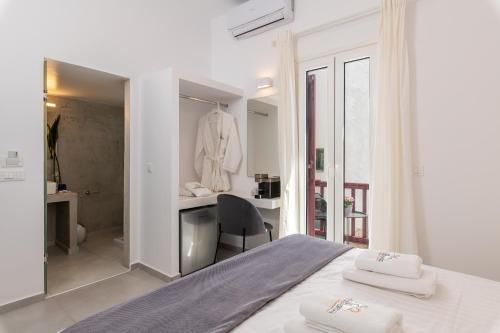 a bedroom with a bed and a desk and a chair at Sunset Paraportiani Rooms in Mýkonos City