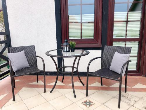 a table and two chairs on a porch with a table at Dom Aptekarza in Ustka