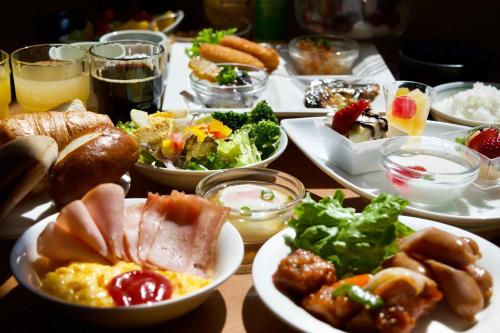 ein Tisch mit vielen Tellern voller Essen in der Unterkunft Hotel Route-Inn Sapporo Chuo in Sapporo