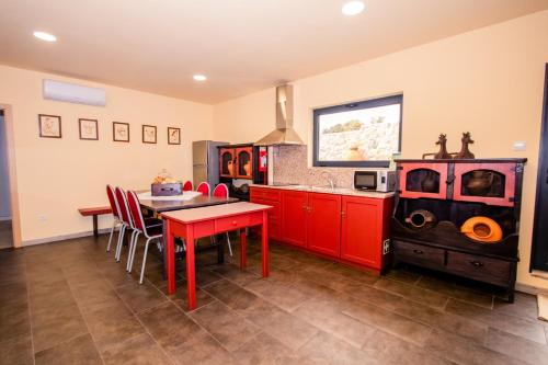 a kitchen with red cabinets and a red table at A Queijaria in Barreira