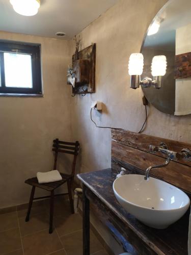 a bathroom with a sink and a mirror and a chair at GA Grudzianka in Lwówek