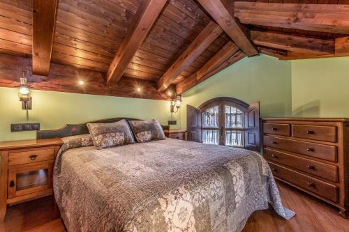 1 dormitorio con cama grande y techo de madera en Apartamentos Casa Rivera, en Aínsa