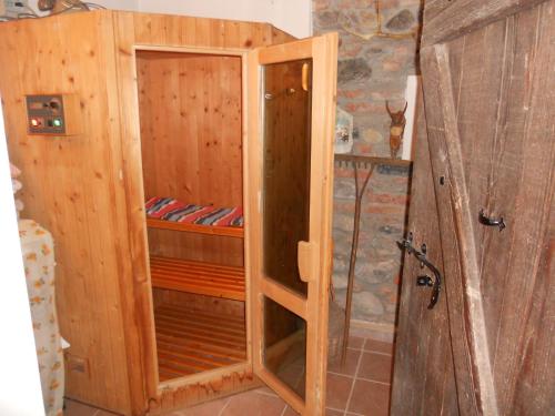 a wooden shower stall with a wooden door at B&B Pervinca in Rocca Grimalda