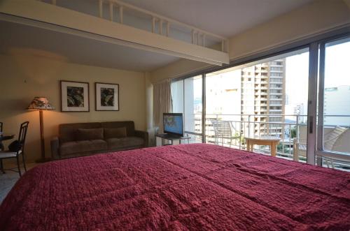 ein Schlafzimmer mit einem großen roten Bett und einem Sofa in der Unterkunft IH805 Waikiki 1777 Ala Moana Blvd Honolulu in Honolulu