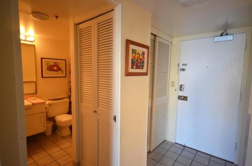 ein Bad mit einem WC und einer weißen Tür in der Unterkunft IH805 Waikiki 1777 Ala Moana Blvd Honolulu in Honolulu