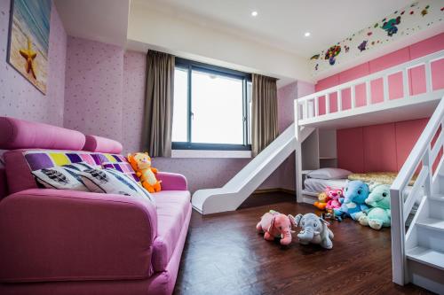 a pink room with a bunk bed and stuffed animals at Red hotel in Yuanlin
