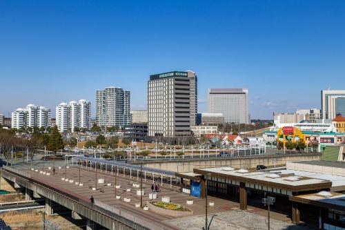 a train station with a city in the background at Hotel Route Inn Chiba Newtown Chuo Ekimae -Narita Kuko Akusesu Sen- in Inzai