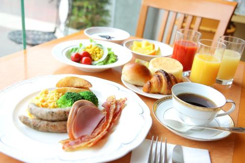 a table with plates of breakfast foods and a cup of coffee at Hotel Nikko Tsukuba in Tsukuba