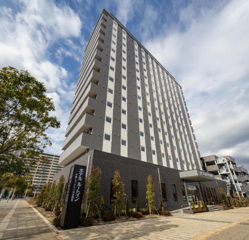 a tall building with a sign in front of it at Hotel Route Inn Chiba Newtown Chuo Ekimae -Narita Kuko Akusesu Sen- in Inzai