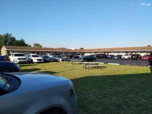 a parking lot with parked cars and a picnic table at Driftwood Motel in Niagara Falls
