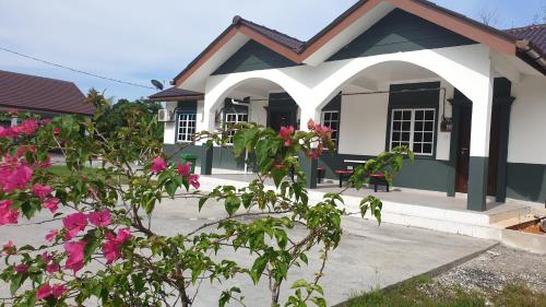 a small house with pink flowers in front of it at MRI Residence - Homestay in Sg Buloh with Swimming Pool - No Pork&Alcohol Allowed in Bandar Puncak Alam