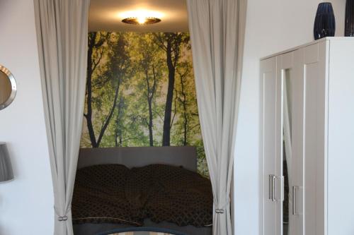 una camera da letto con finestra con quadro di alberi di Apartment am Kurpark a Sankt Andreasberg