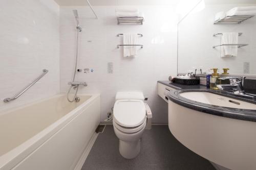 a white bathroom with a toilet and a sink at Hotel Tenjin Place in Fukuoka