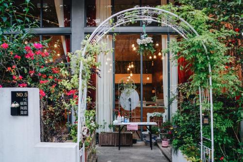 uma sala de jardim com uma mesa e muitas plantas em Ancient Street No.5 Youth Chic Hotel em Wuyishan