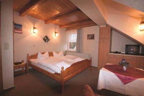 a bedroom with a large bed and a tv in it at Pension Barbara in Schierke