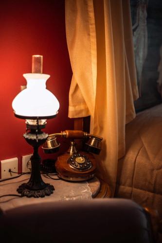 a table with a telephone and a lamp on it at Ilion Hotel in Nafplio