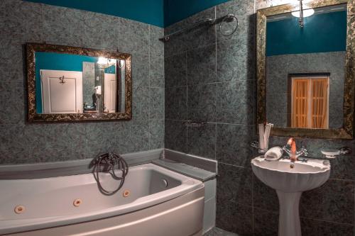 a bathroom with a tub and a sink and a mirror at Ilion Hotel in Nafplio