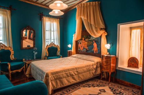 - une chambre avec des murs bleus, un lit et des chaises dans l'établissement Ilion Hotel, à Nauplie