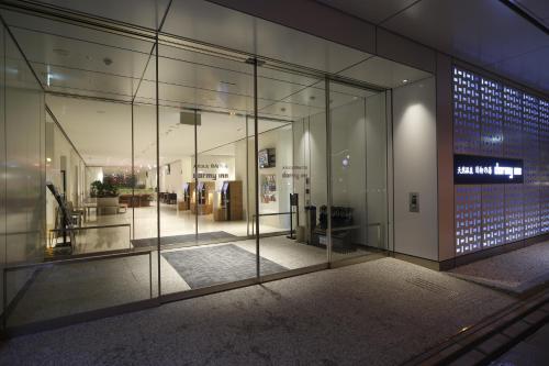a building with glass walls and a lobby with a lot ofolean at Dormy Inn Miyazaki Natural Hot Spring in Miyazaki