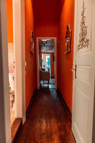 a hallway with orange walls and wooden floors at Ilion Hotel in Nafplio