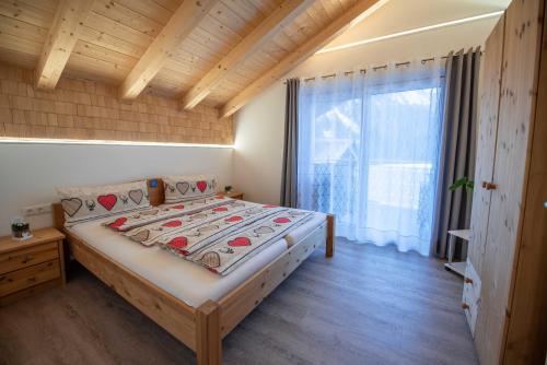 ein Schlafzimmer mit einem Bett und einem großen Fenster in der Unterkunft Ferienwohnung Trocker in Krimml