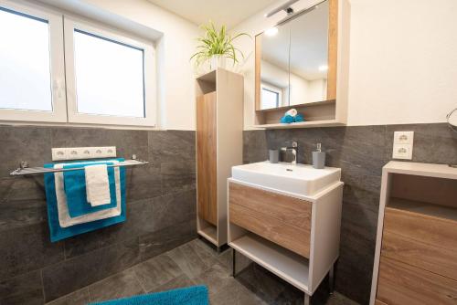 ein Bad mit einem Waschbecken und einem Spiegel in der Unterkunft Ferienwohnung Trocker in Krimml