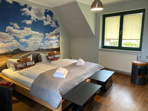 a bedroom with a large bed with a painting on the wall at Hotel-Pension Mandy - Adults Only in Senftenberg