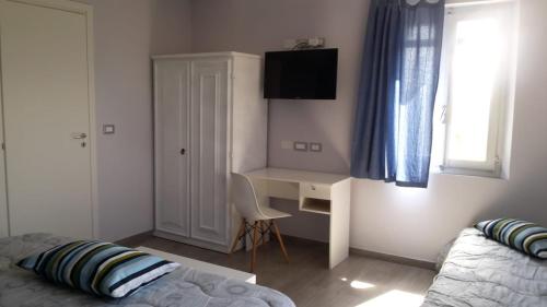 a bedroom with a bed and a desk with a computer at Sotto l'Ulivo in Mondavio