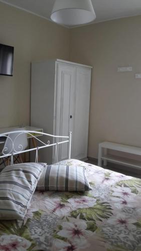 a bedroom with a bed with a floral bedspread at Sotto l'Ulivo in Mondavio