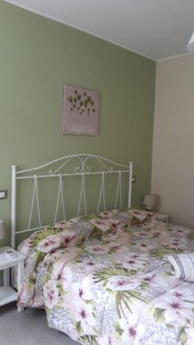 a bedroom with a bed with a floral bedspread at Sotto l'Ulivo in Mondavio